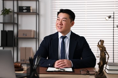 Happy notary working at wooden table in office