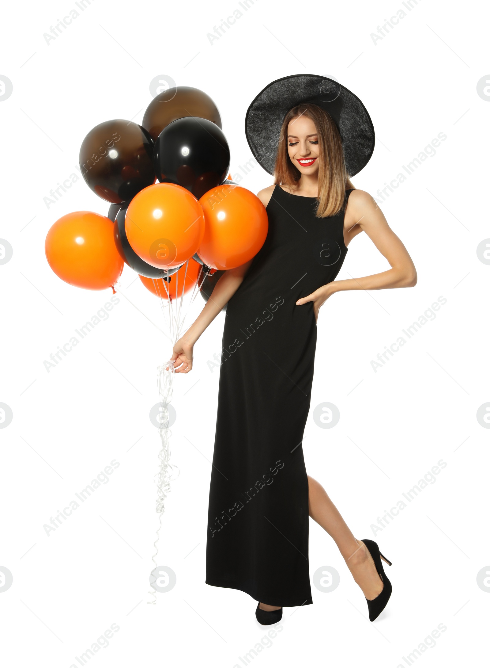 Photo of Beautiful woman wearing witch costume with balloons for Halloween party on white background