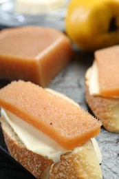 Photo of Tasty sandwiches with quince paste on board, closeup