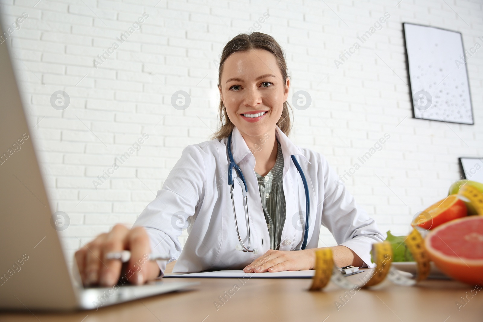 Photo of Nutritionist working with laptop at desk in office