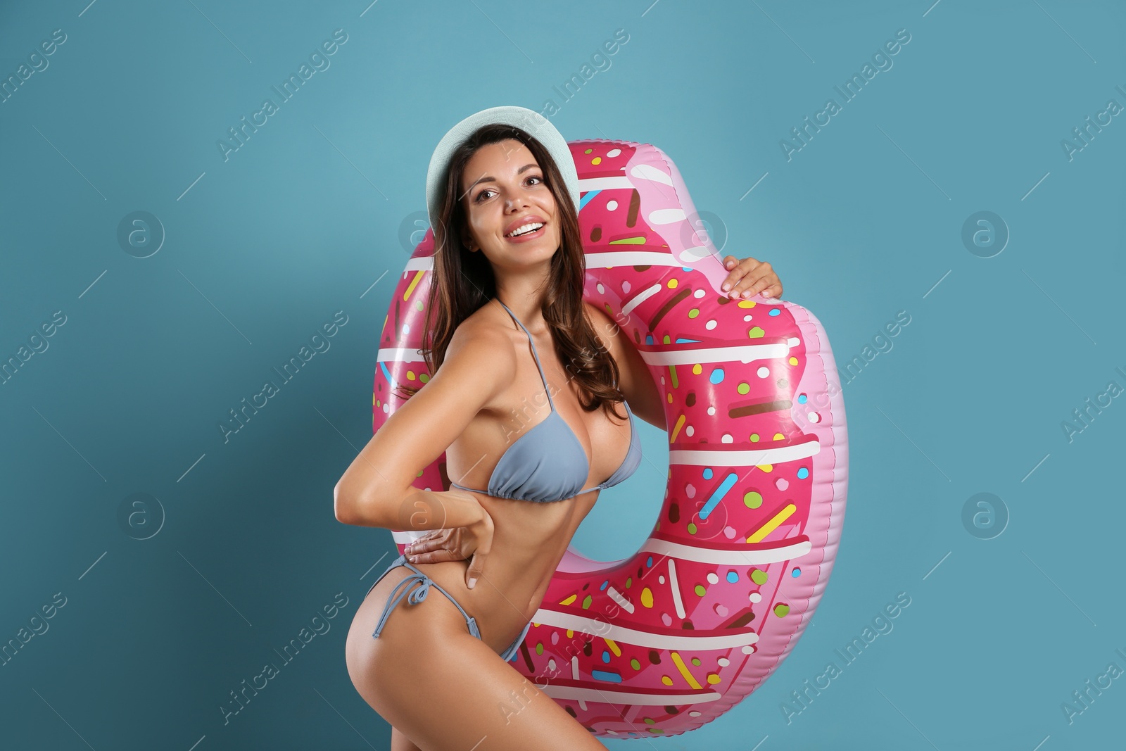 Photo of Beautiful woman in stylish bikini with inflatable ring on blue background