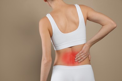 Image of Woman suffering from pain in back on beige background, closeup