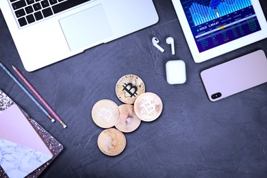 Image of Bitcoins, stationery and different gadgets on grey table, flat lay