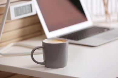 Photo of Coffee cup on table at modern workplace in office