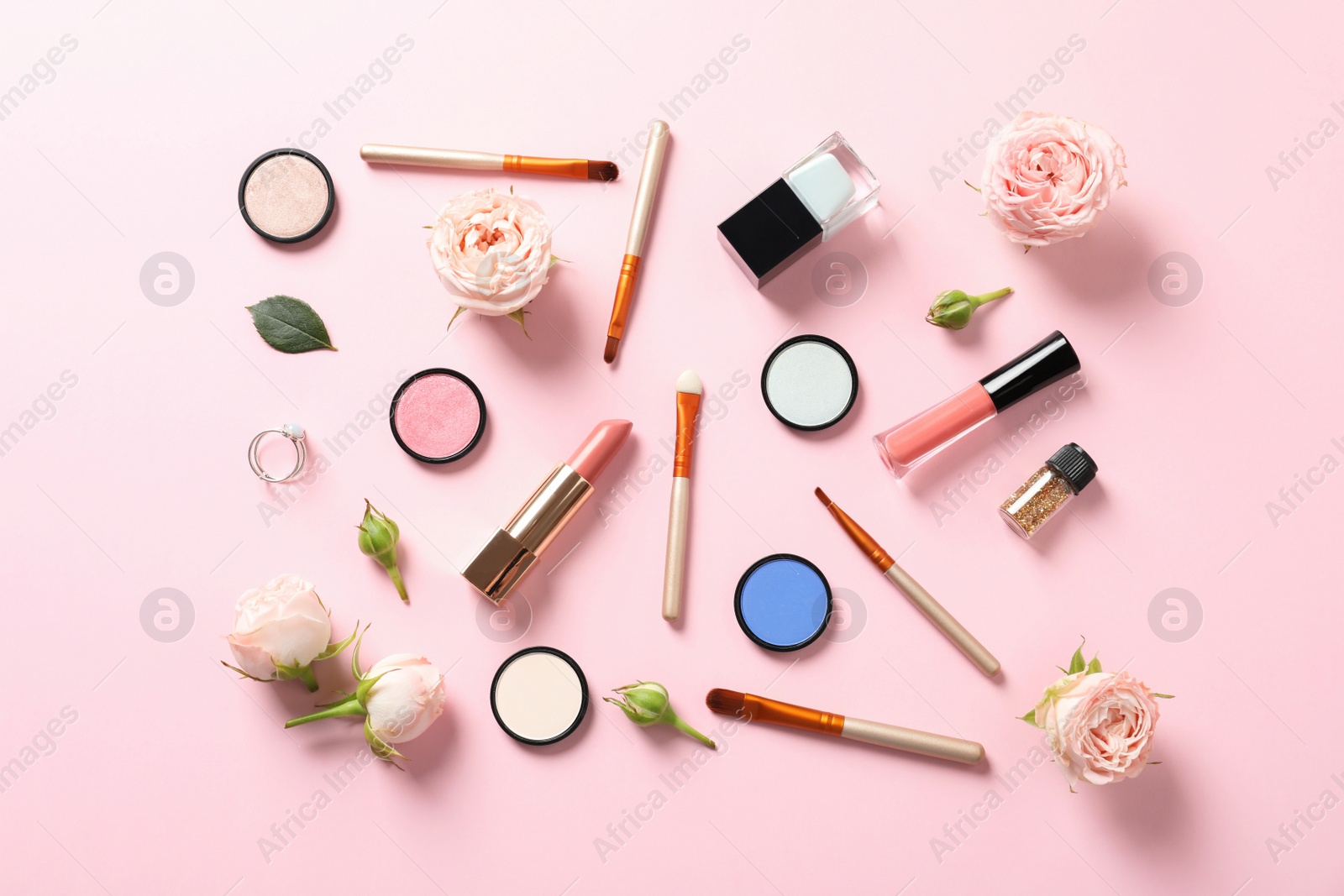 Photo of Flat lay composition with products for decorative makeup on pastel pink background