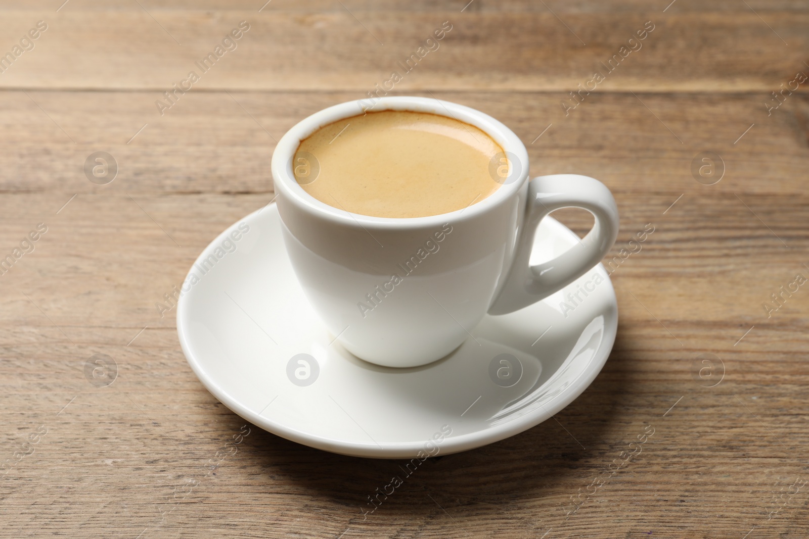 Photo of Aromatic coffee in cup on wooden table