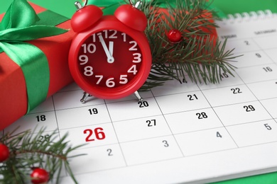 Gifts and alarm clock on calendar with marked Boxing Day date, closeup