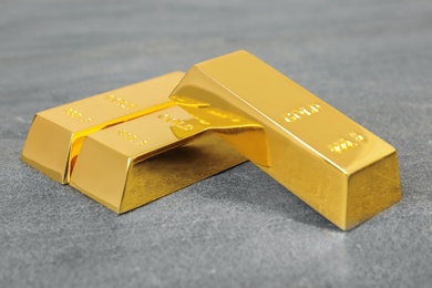 Photo of Three shiny gold bars on grey table