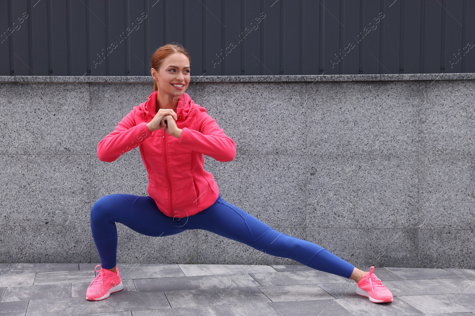 Photo of Beautiful woman in gym clothes doing exercises on street