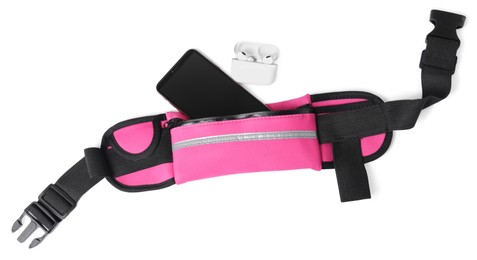 Stylish pink waist bag with smartphone and earphones on white background, top view