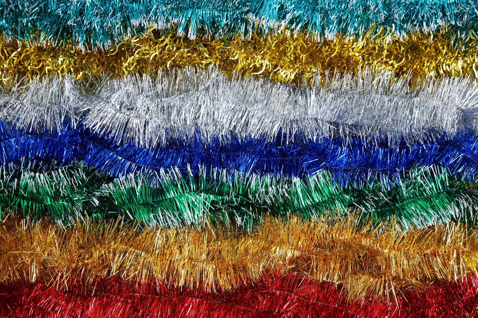 Photo of Many colorful tinsels as background, top view