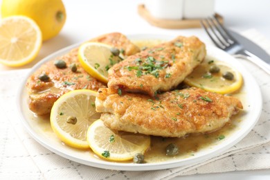 Delicious chicken piccata served on white table, closeup