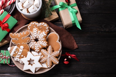 Photo of Delicious Christmas cookies on black wooden table table, flat lay