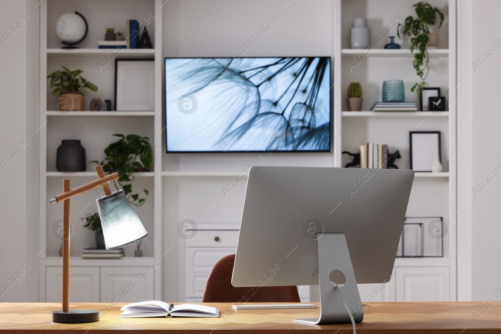 Photo of Cosy workplace with computer near tv area. Interior design