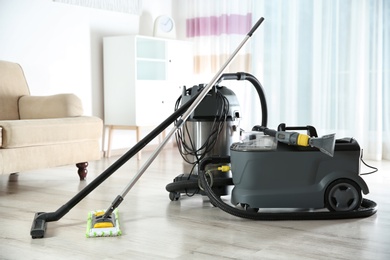 Photo of Professional cleaning equipment on floor indoors, space for text