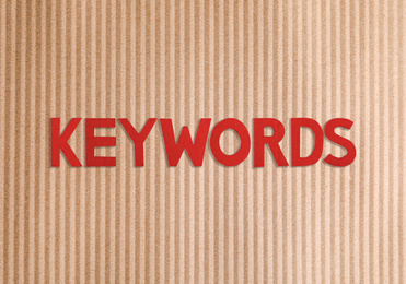 Image of Text KEYWORDS on brown corrugated sheet of cardboard, top view