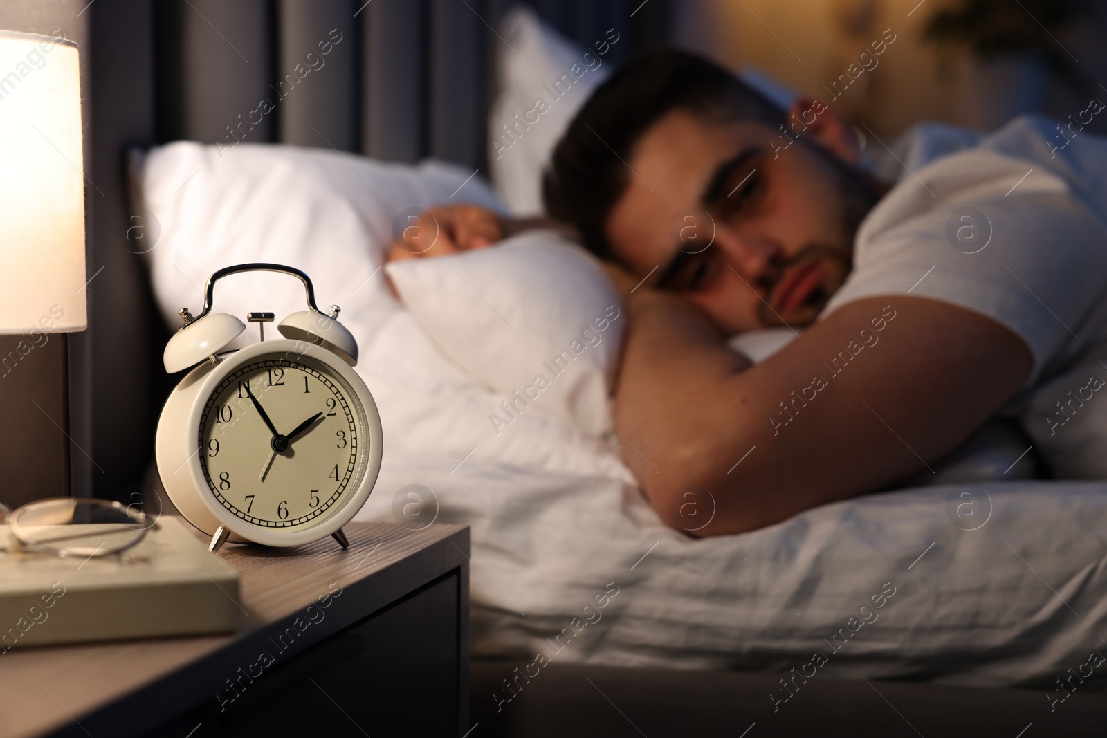 Photo of Frustrated man suffering from insomnia on bed, selective focus