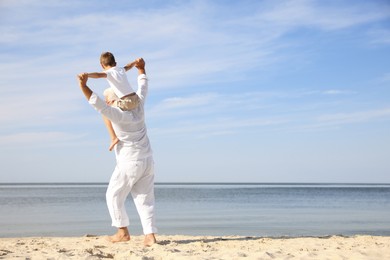 Cute little boy with grandfather spending time together on sea beach