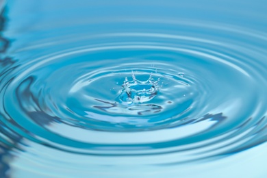 Photo of Splash of blue water with drop, closeup