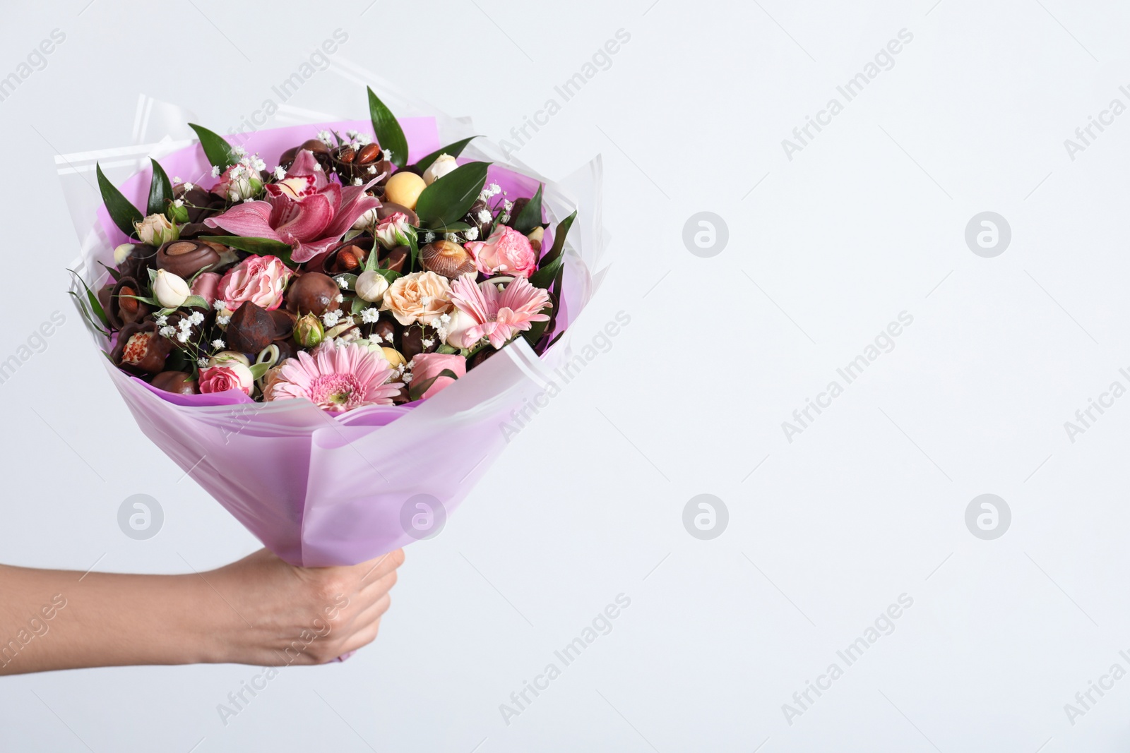 Photo of Woman with beautiful edible bouquet on white background, closeup. Space for text