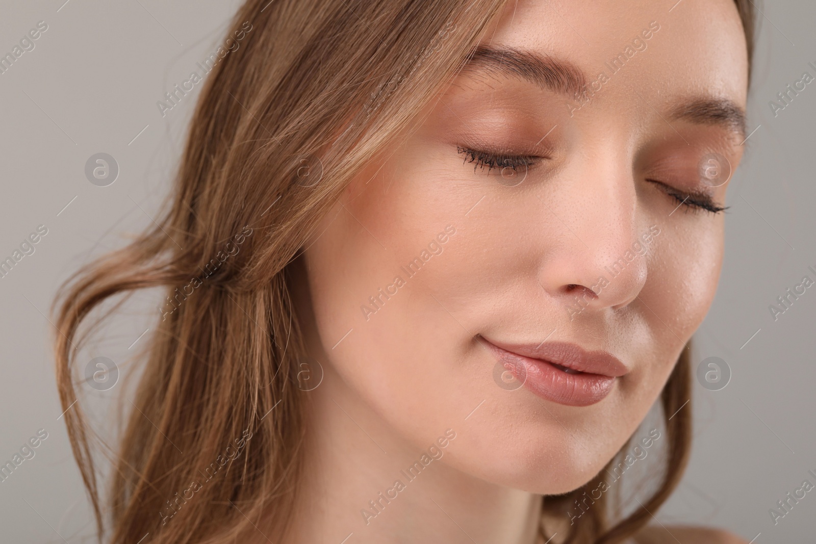 Photo of Beautiful woman with healthy skin on gray background, closeup