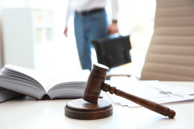 Photo of Judge's gavel, law books and papers on table in notary office