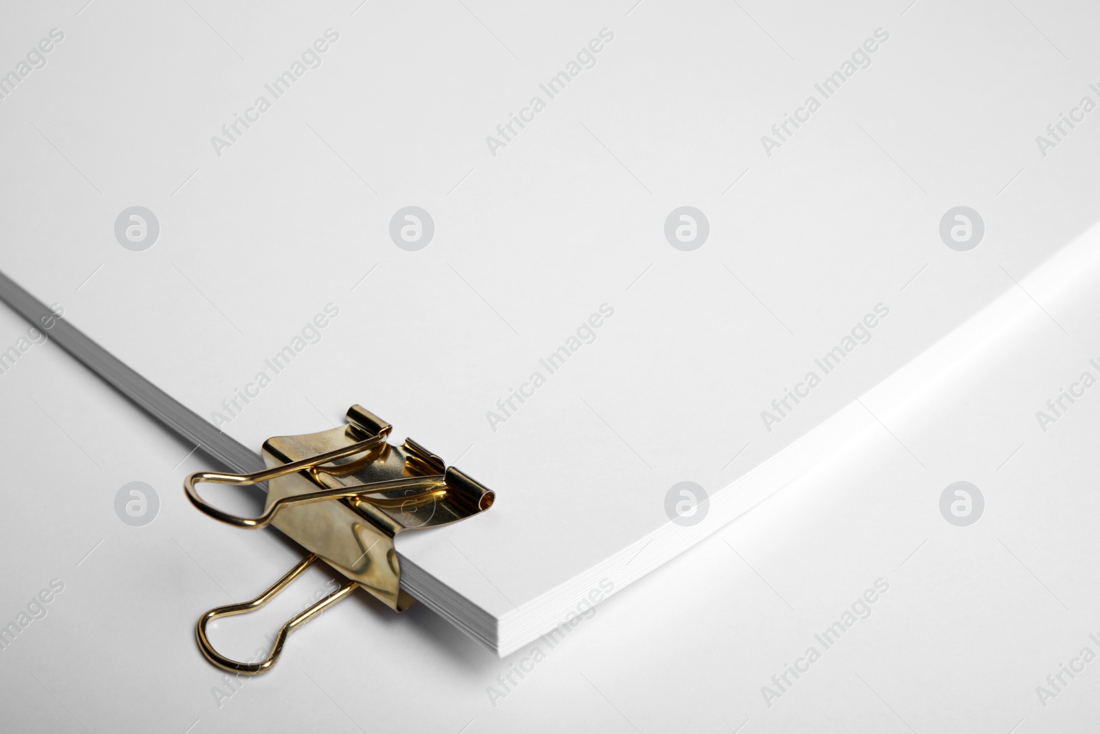 Photo of Sheets of paper with clip on white background, closeup