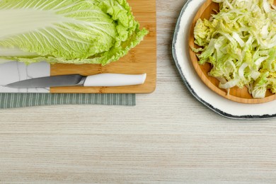 Photo of Whole and cut fresh ripe Chinese cabbage on white wooden table, flat lay