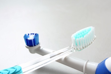 Electric and manual toothbrushes on gray background