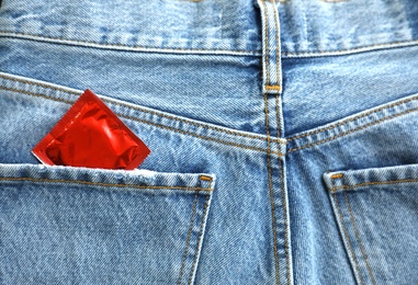 Photo of Closeup view of jeans with condom in pocket. Safe sex concept