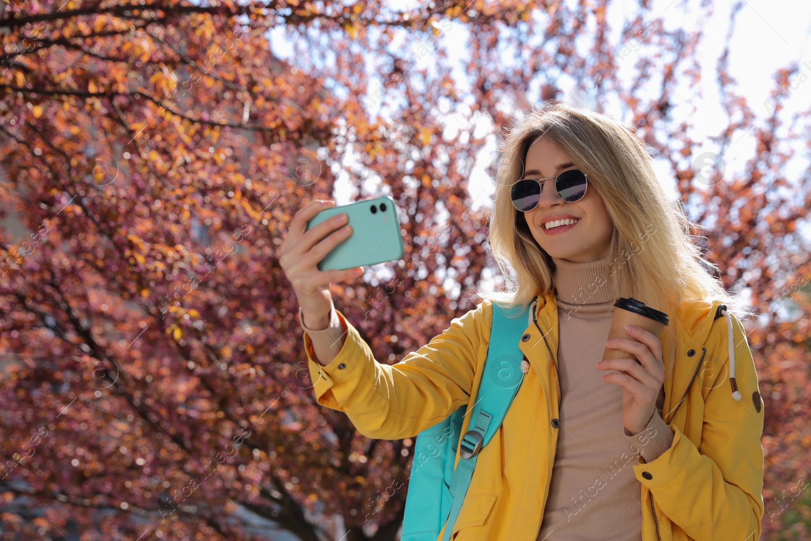 Photo of Young woman taking selfie on city street