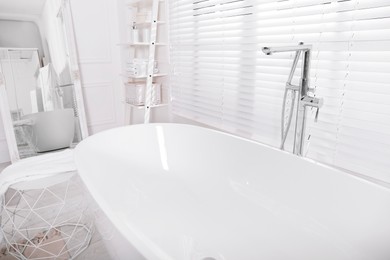 Photo of Modern white tub in bathroom. Interior design