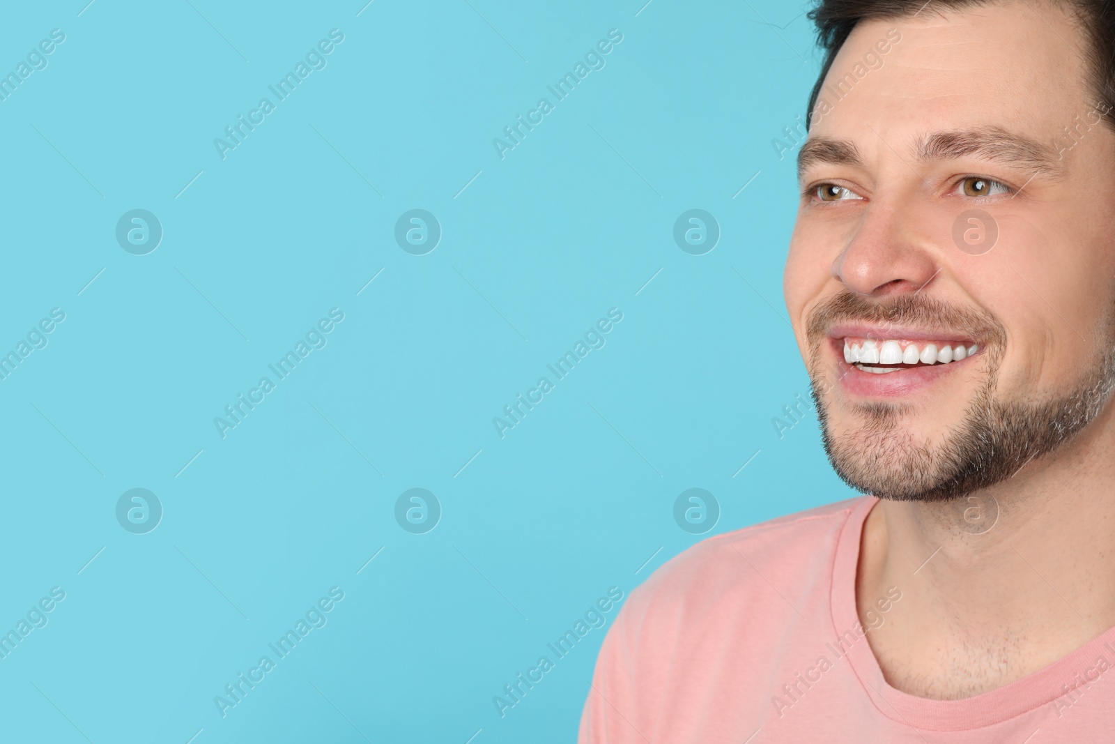 Photo of Smiling man with perfect teeth on color background. Space for text