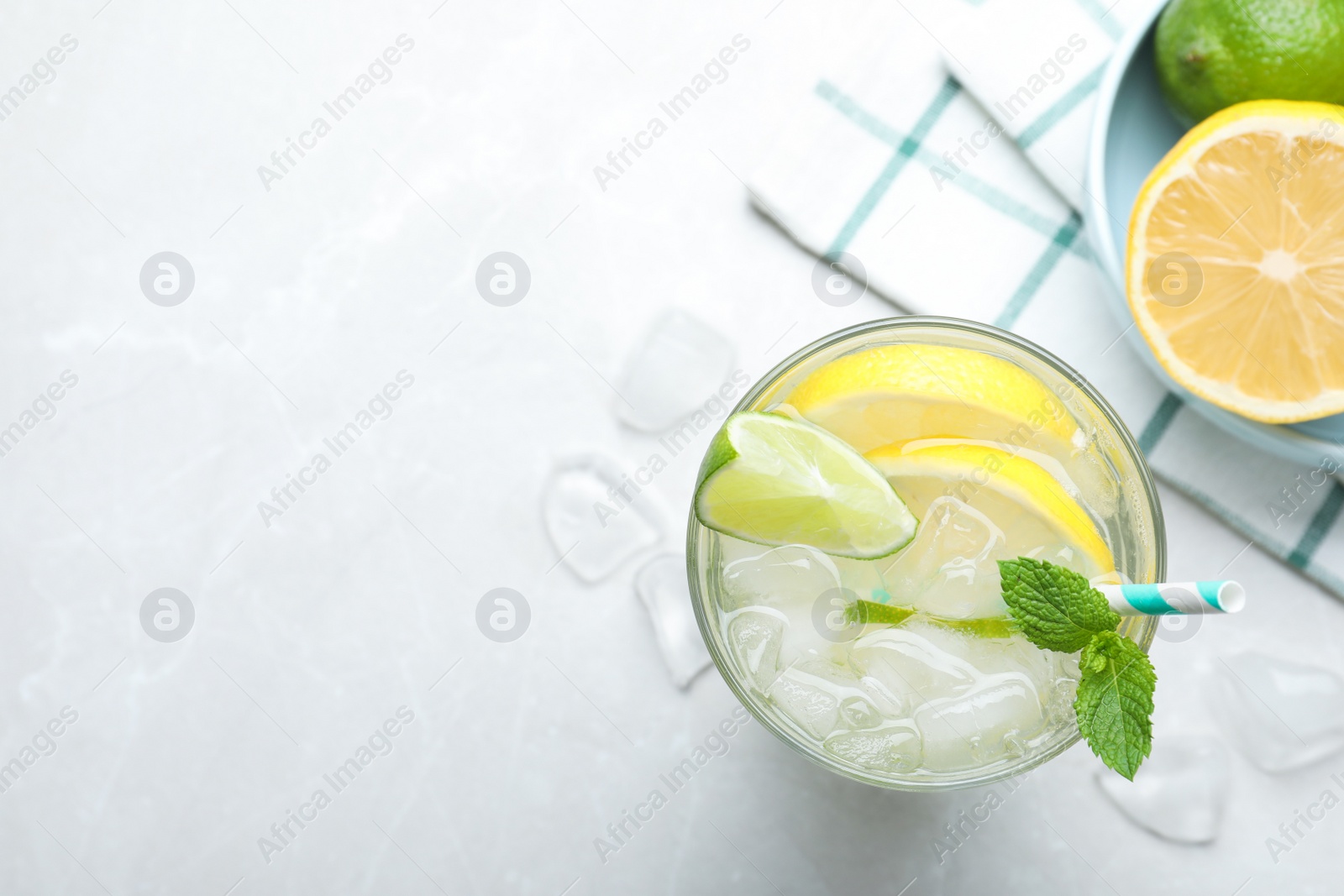 Photo of Flat lay composition of delicious lemonade with soda water and mint on light grey table, space for text. Fresh summer cocktail