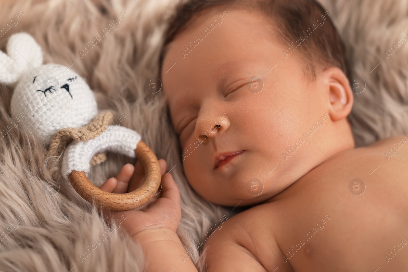 Photo of Cute newborn baby with toy sleeping on fluffy blanket, closeup