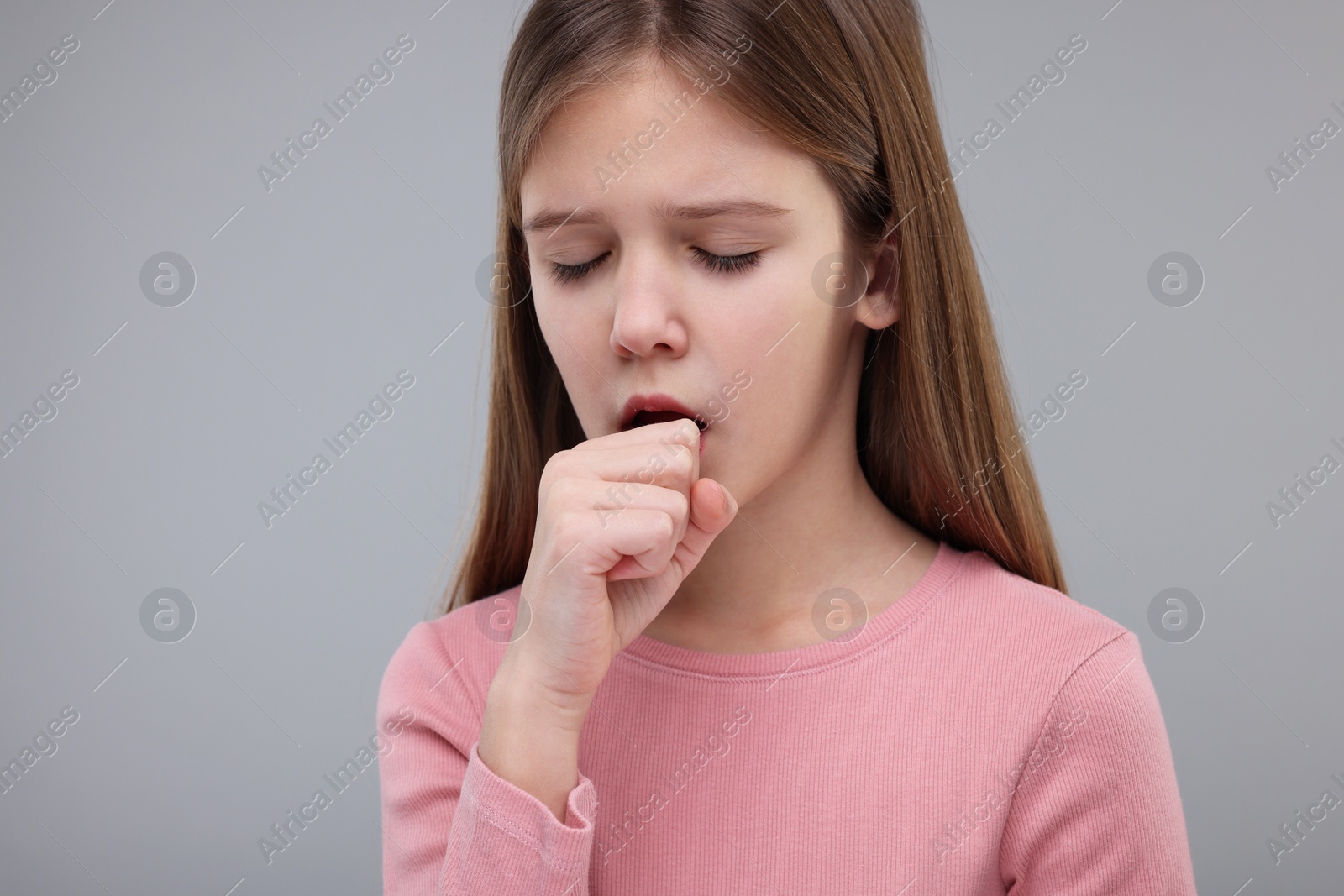 Photo of Sick girl coughing on gray background. Cold symptoms