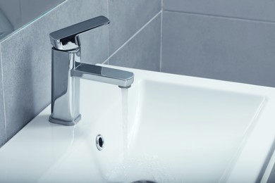 Photo of Stream of water flowing from tap in bathroom