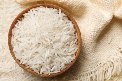 Photo of Raw basmati rice, bowl and cloth, top view