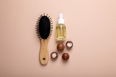 Photo of Delicious organic Macadamia nuts, cosmetic oil and brush on beige background, flat lay