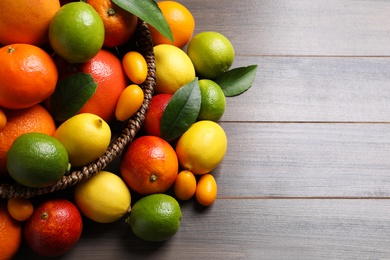 Photo of Different citrus fruits on wooden table, flat lay. Space for text