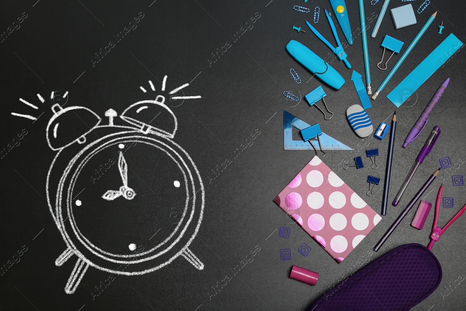 Image of Different stationery and drawn alarm clock on blackboard surface, flat lay. Time to school