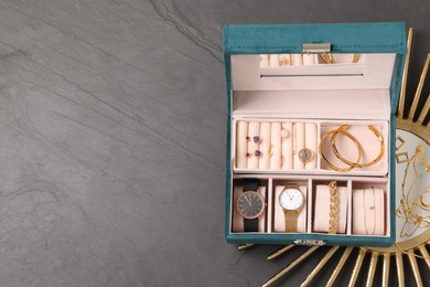 Photo of Jewelry box with many different accessories and decor on black table, flat lay. Space for text