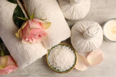 Photo of Flat lay composition with spa products, roses and burning candle on grey textured table