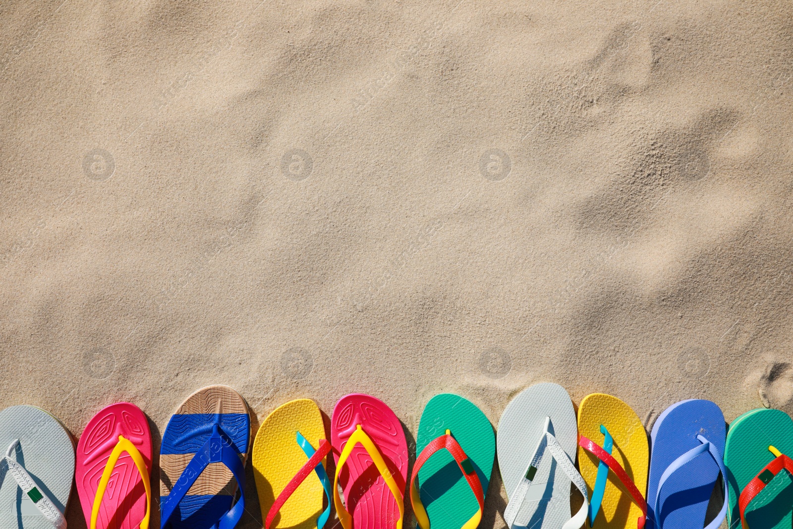 Photo of Stylish flip flops on beach, flat lay. Space for text