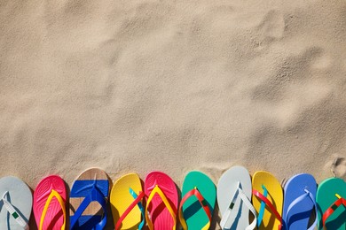 Stylish flip flops on beach, flat lay. Space for text