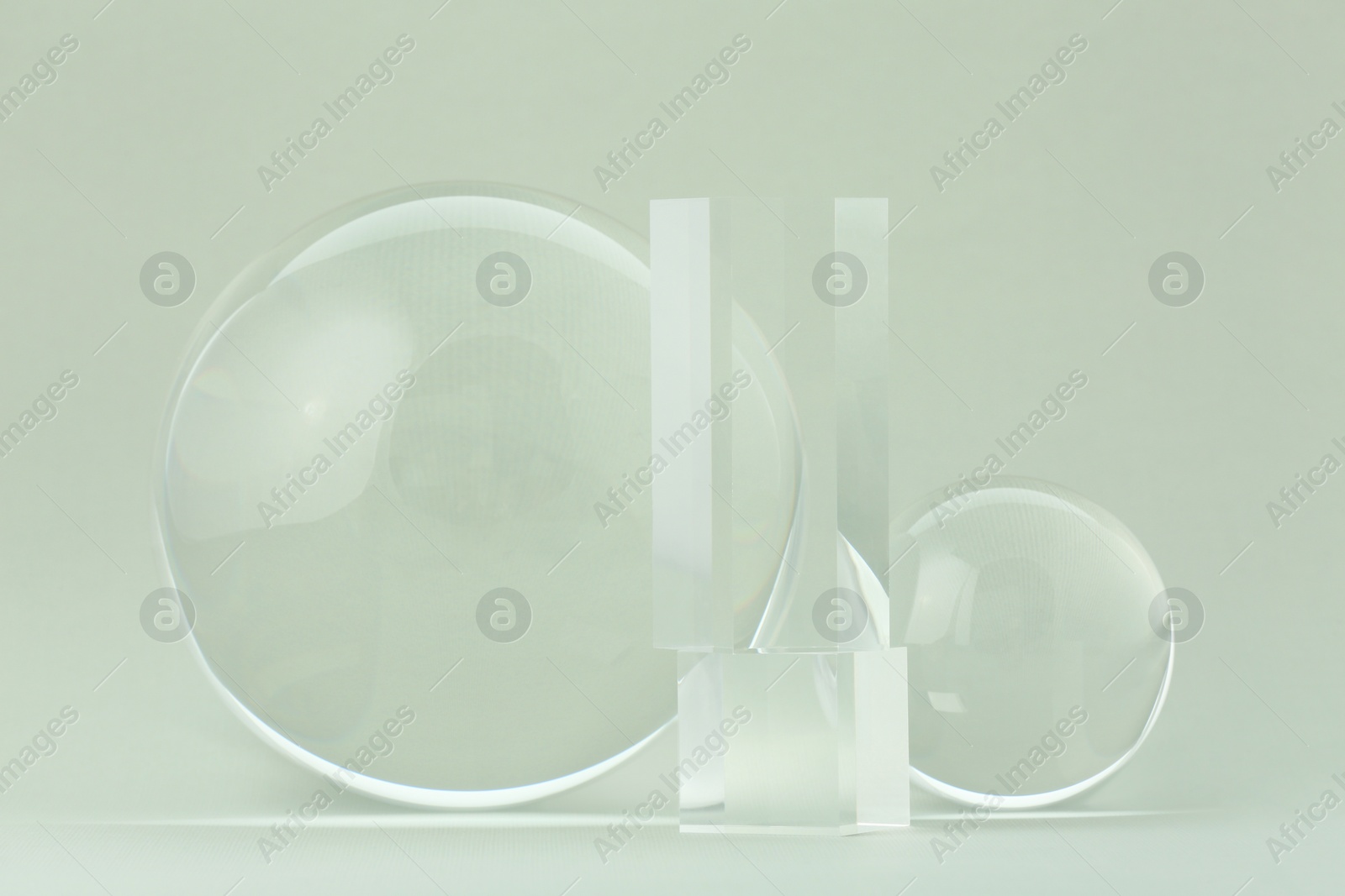 Photo of Transparent glass balls and cubes on light grey background