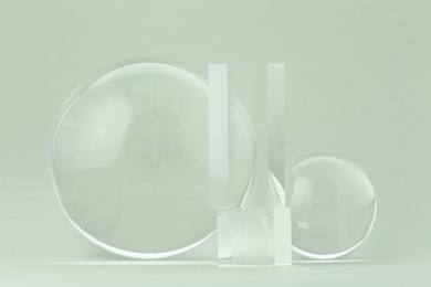 Transparent glass balls and cubes on light grey background
