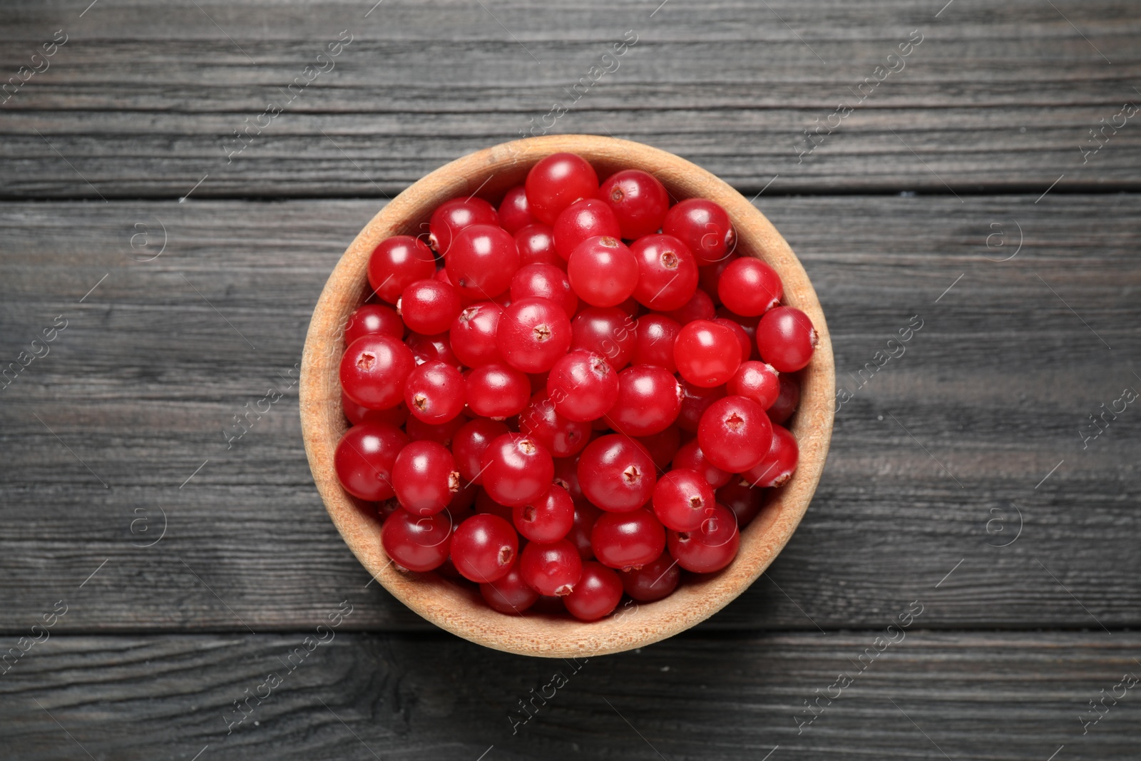 Photo of Ripe fresh cranberry on grey wooden table, top view