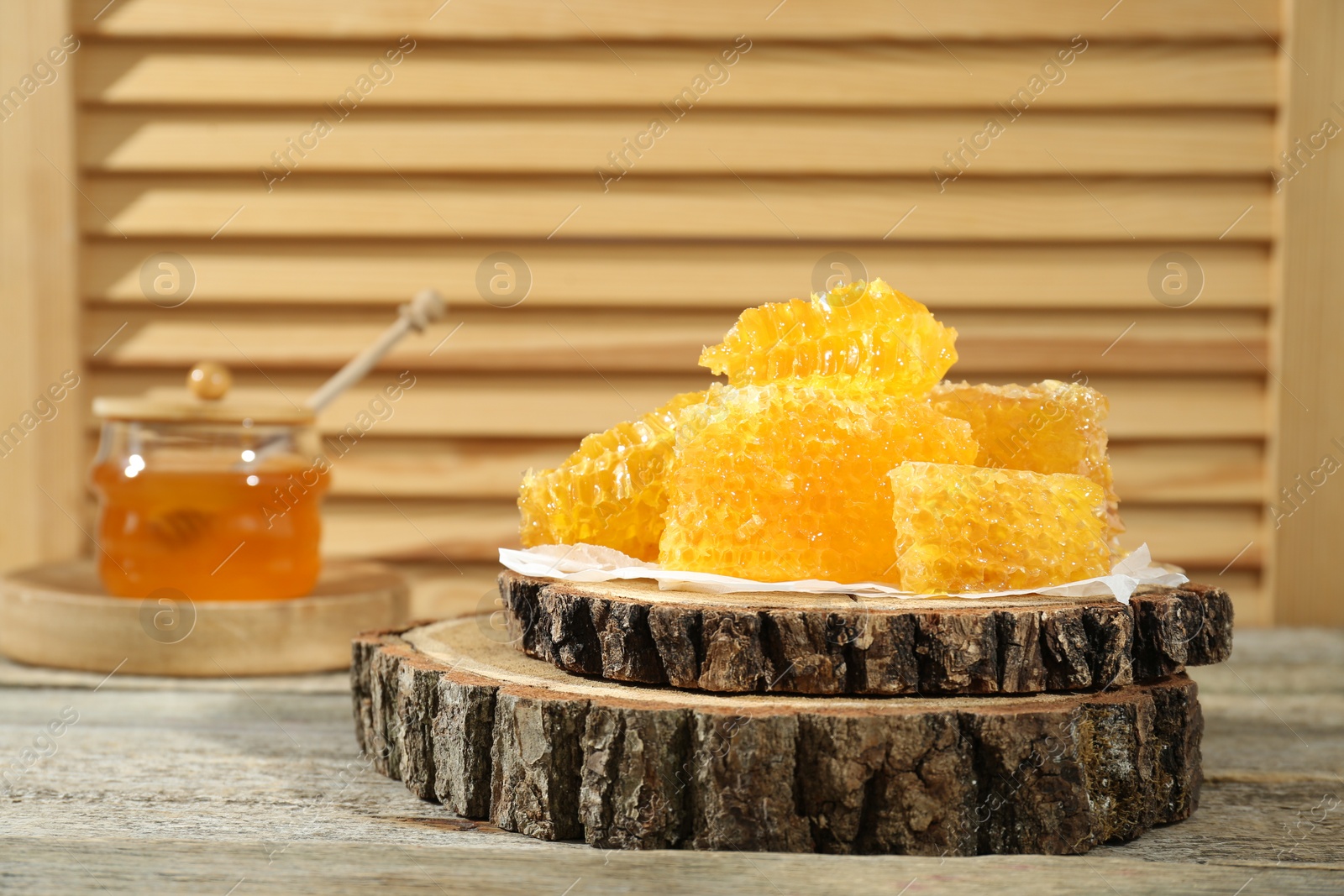 Photo of Natural honeycombs with honey on rustic table, space for text