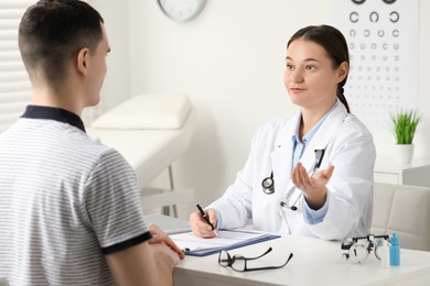 Photo of Vision testing. Young man having appointment with ophthalmologist in clinic